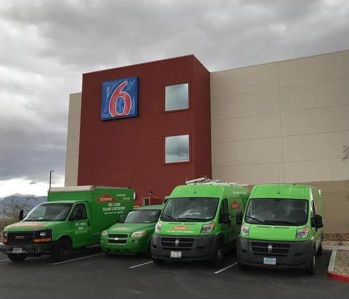Four SERVPRO vehicles parked in front of a building